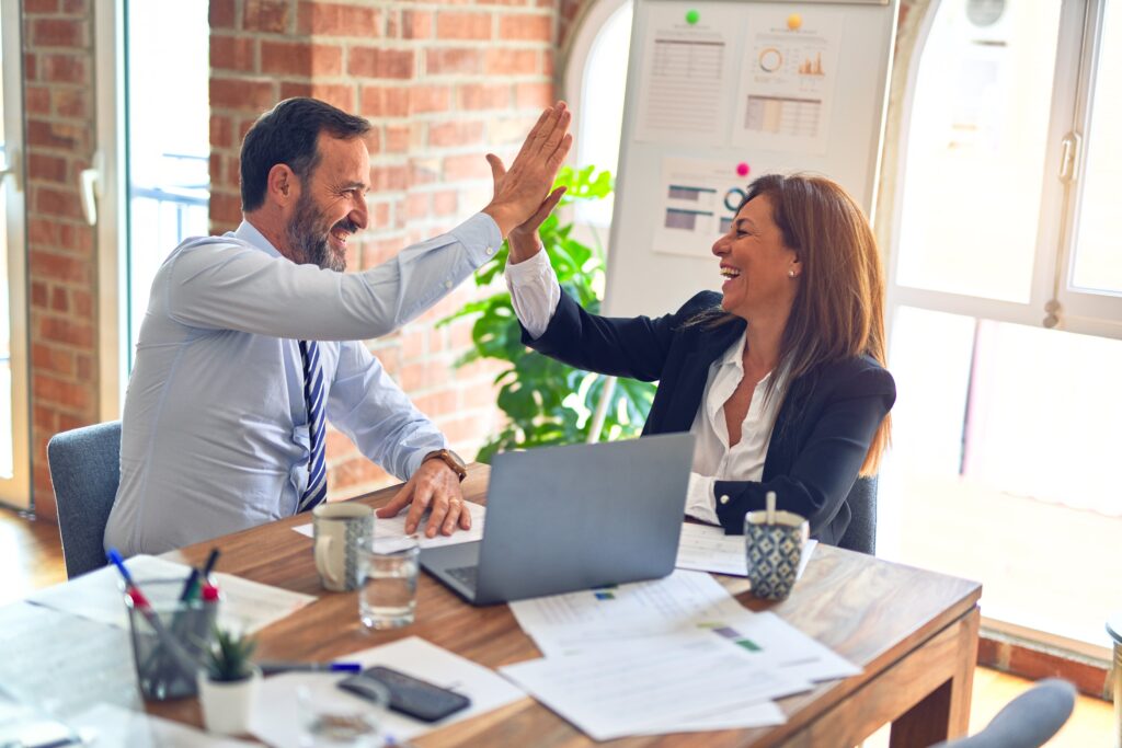 high five couple with laptop